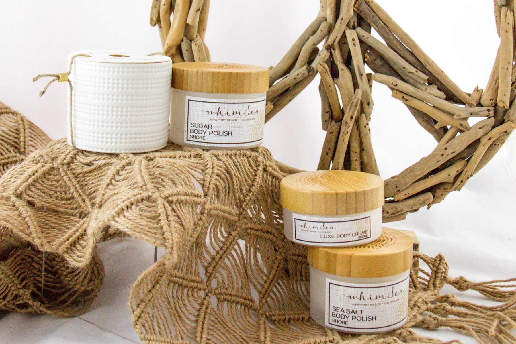 WhimSea product lineup on macrame with a driftwood wreath